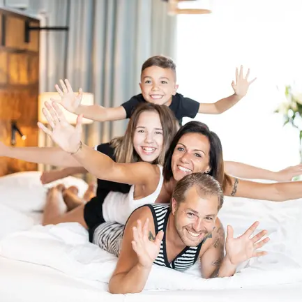 Familie liegt im Bett im Thermenhotel Vier Jahreszeiten