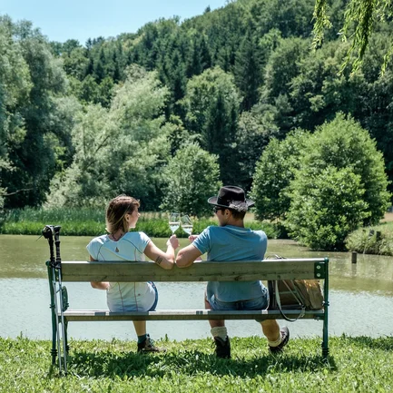 Pärchen sitzt auf einer Bank am See in der Region Loipersdorf