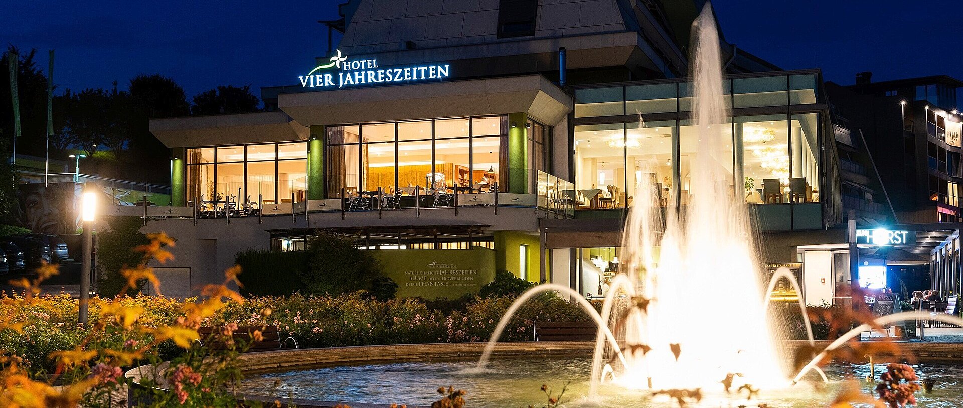 Beleuchteter Springbrunnen bei Nacht vor dem Thermenhotel Vier Jahreszeiten
