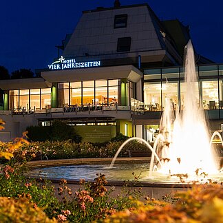 Beleuchteter Springbrunnen bei Nacht vor dem Thermenhotel Vier Jahreszeiten