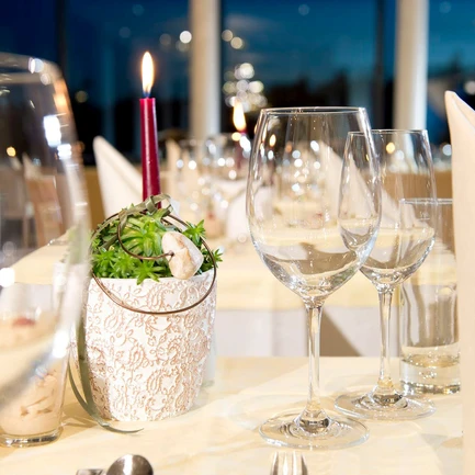 Weingläser am gedeckten Tisch am Abend im Thermenhotel Vier Jahreszeiten