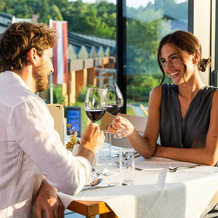 Paar trinkt einen Rotwein auf der Terrasse im Thermenhotel Vier Jahreszeiten