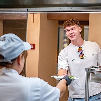 A chef with a guest at the cooking station at Thermenhotel Vier Jahreszeiten.