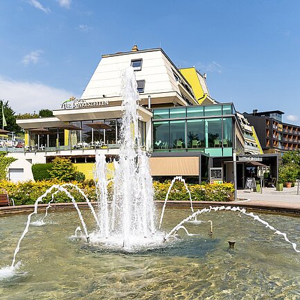 Springbrunnen bei blauem Himmel vor dem Thermenhotel Vier Jahreszeiten